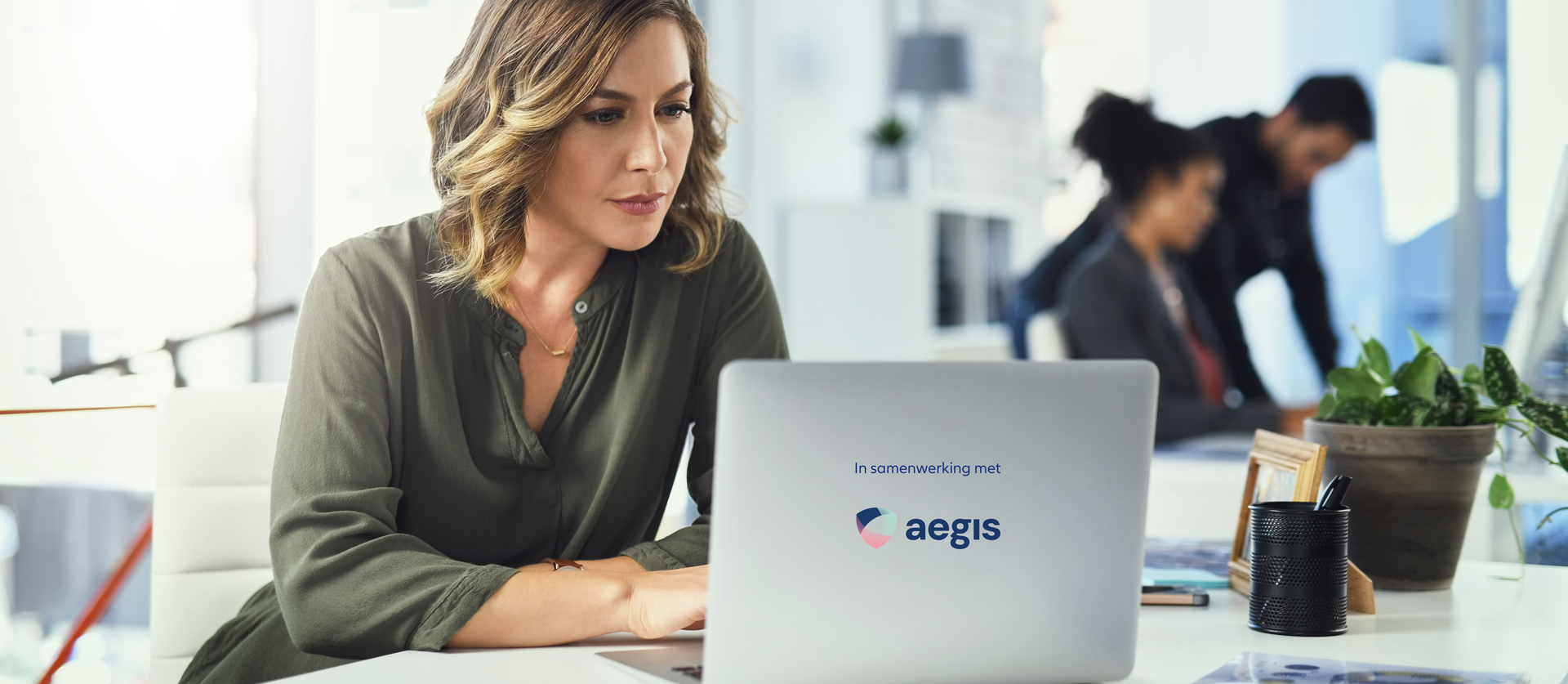 vrouw achter laptop met logo van Aegis
